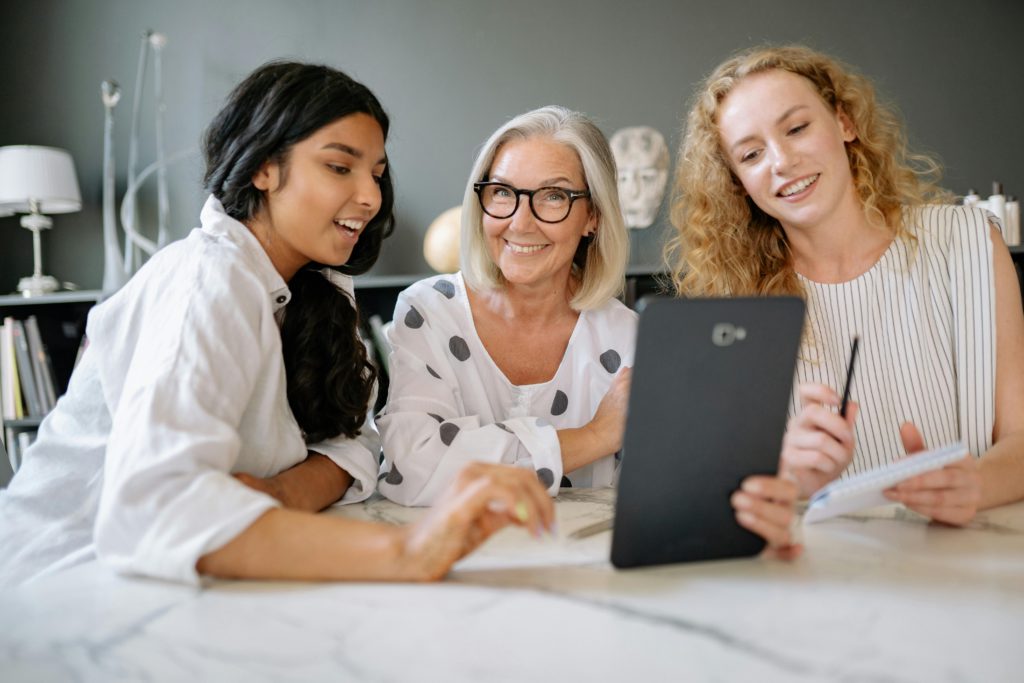 AngelUs - liderança feminina. 3 mulheres de diferentes gerações interagindo juntas